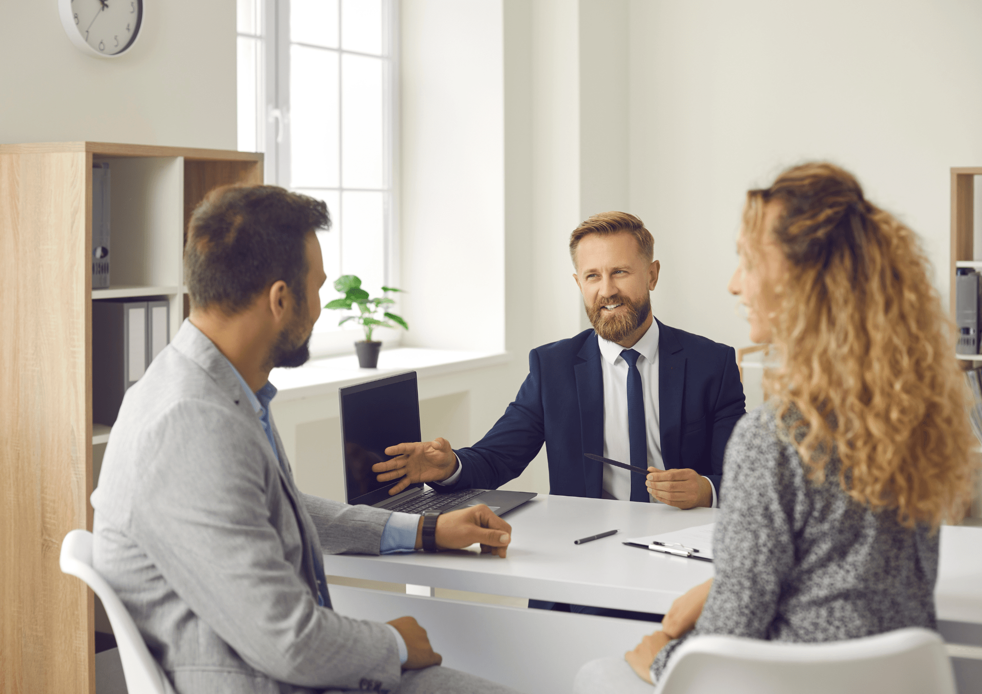 Agentes inmobiliarios hablando con pareja gestionando y redactando la compra de su casa