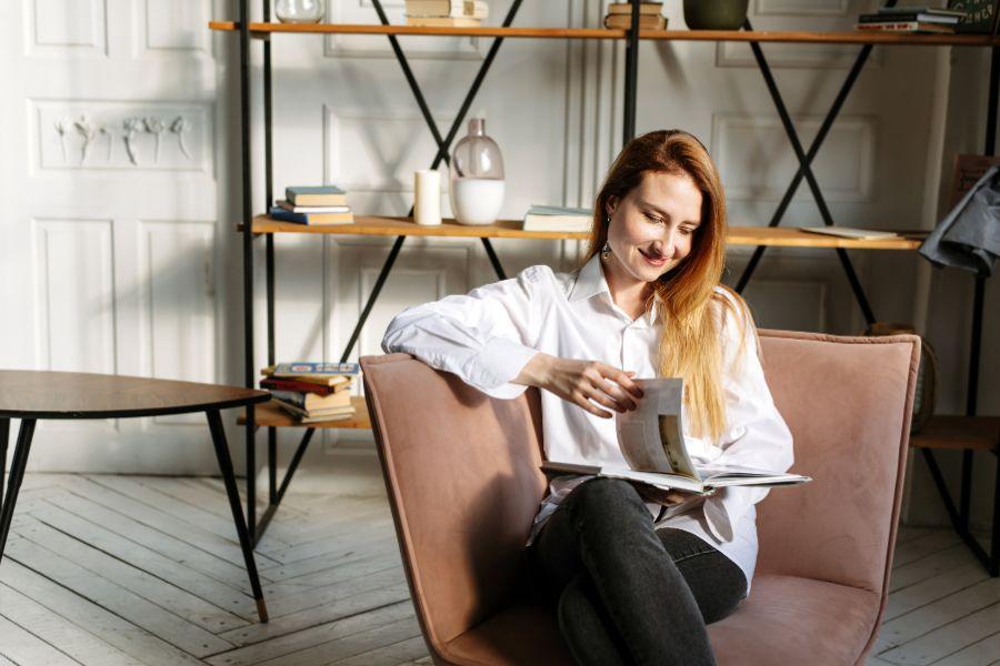 chica mirando revista en espacio decorado de forma minimalista